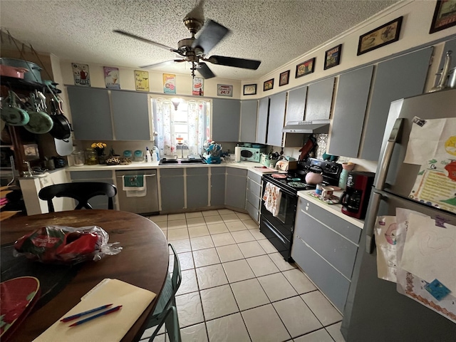 kitchen featuring gray cabinets, a sink, appliances with stainless steel finishes, light countertops, and light tile patterned floors