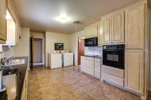 kitchen featuring visible vents, light brown cabinets, independent washer and dryer, black appliances, and a sink