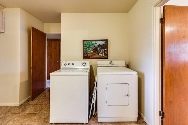 laundry room featuring washing machine and clothes dryer, laundry area, baseboards, and light tile patterned floors