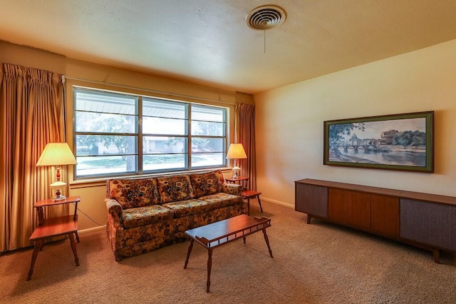 carpeted living area featuring visible vents and baseboards