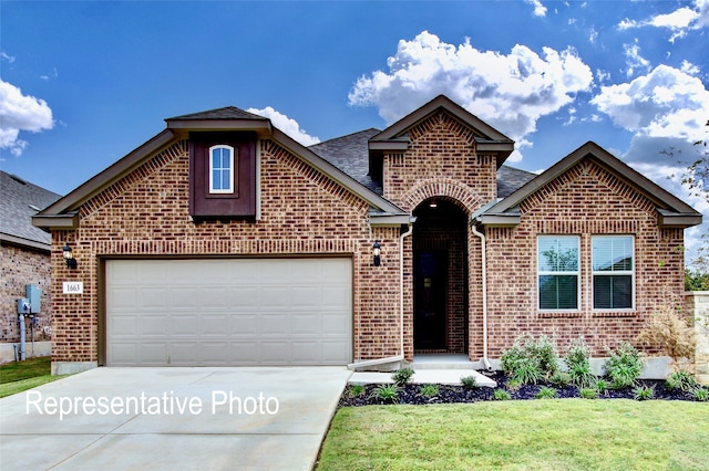 view of front facade with brick siding, driveway, an attached garage, and a front lawn