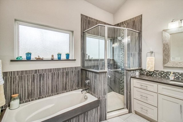 bathroom featuring plenty of natural light, lofted ceiling, a shower stall, and vanity