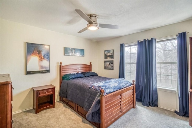 bedroom featuring light carpet, baseboards, and ceiling fan