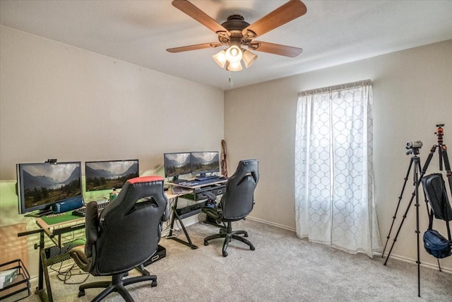 carpeted home office featuring baseboards and ceiling fan