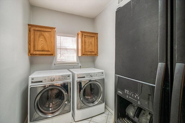 clothes washing area with light tile patterned floors, baseboards, cabinet space, and washing machine and dryer