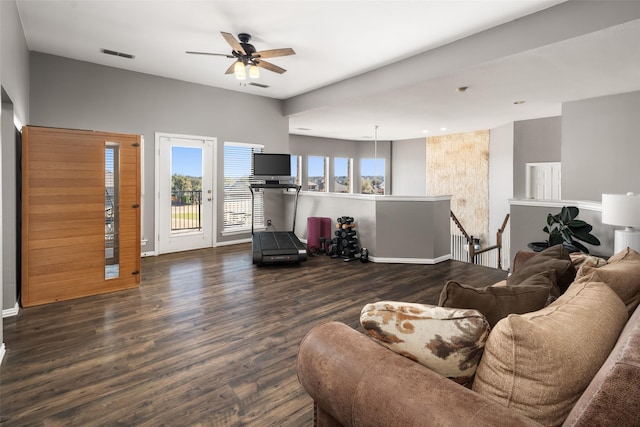 living area featuring baseboards, wood finished floors, visible vents, and ceiling fan