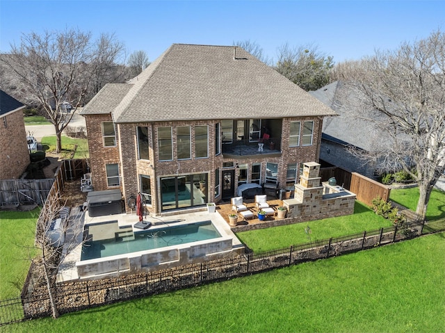 rear view of house with brick siding, a lawn, an outdoor hot tub, and a fenced backyard