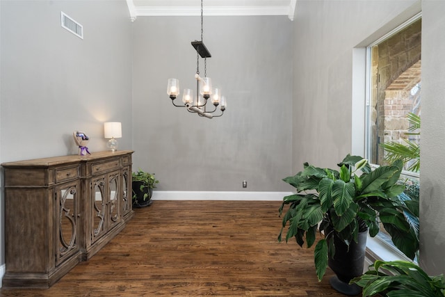 dining space with visible vents, baseboards, wood finished floors, and crown molding