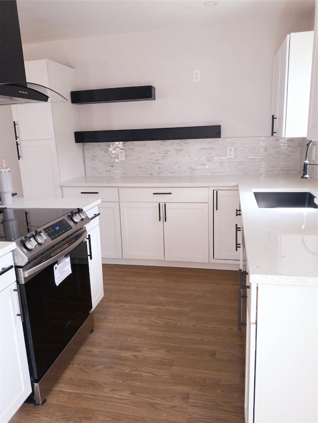 kitchen featuring white cabinetry, wall chimney range hood, stainless steel electric stove, and a sink