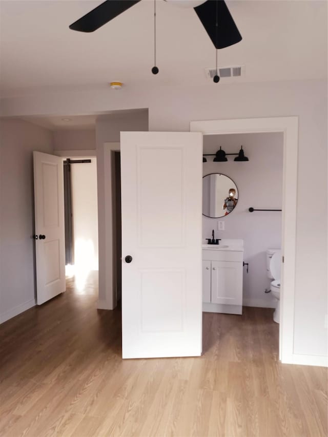 unfurnished bedroom with light wood-style floors, visible vents, and baseboards