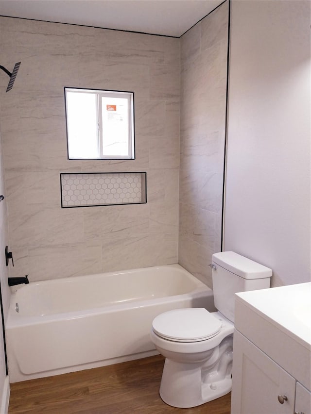 bathroom featuring bathtub / shower combination, toilet, wood finished floors, and vanity