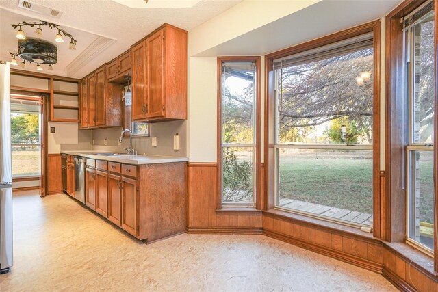 kitchen featuring wooden walls, wainscoting, and a sink