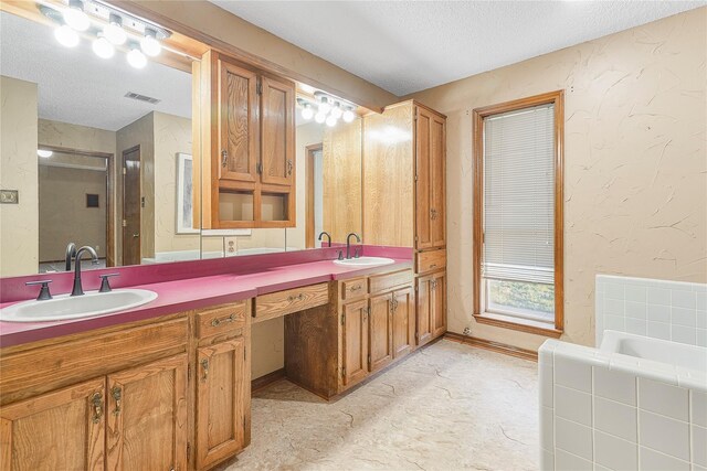 unfurnished bedroom with baseboards, ensuite bath, a tray ceiling, carpet flooring, and a textured wall