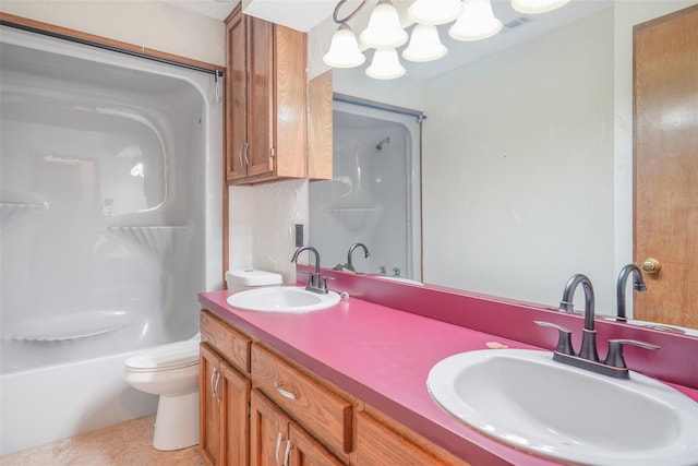 bathroom with double vanity, toilet, and a sink