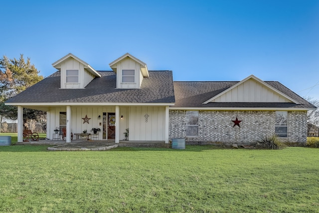 view of front of house featuring a front yard, board and batten siding, and roof with shingles