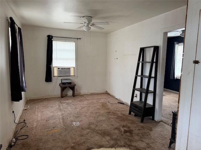 carpeted spare room with cooling unit, baseboards, and a ceiling fan