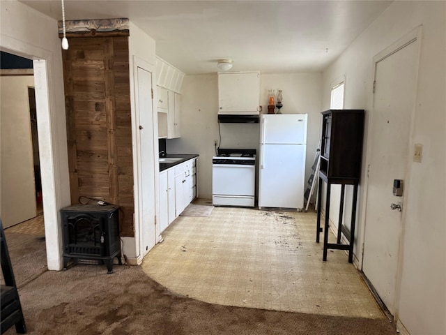 kitchen featuring white appliances, white cabinets, light floors, and under cabinet range hood