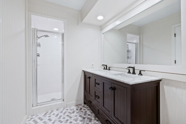 bathroom featuring double vanity, a stall shower, tile patterned floors, and a sink