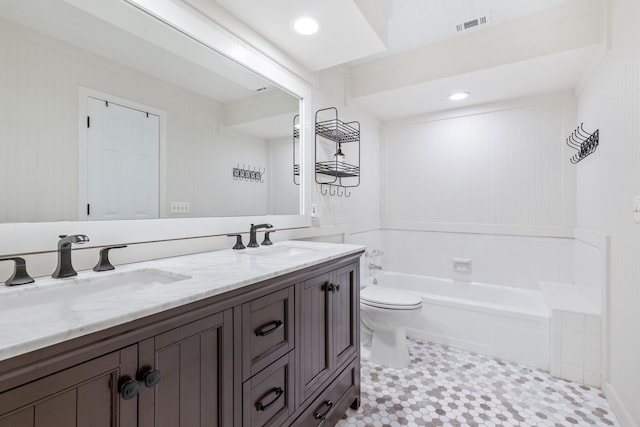 bathroom featuring a sink, a garden tub, double vanity, and toilet