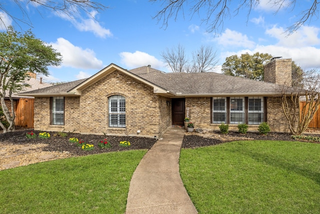 single story home with brick siding, a chimney, a front yard, and fence