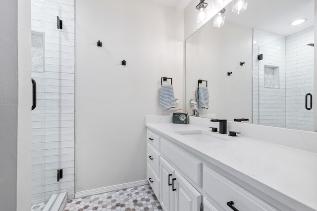 full bathroom featuring tile patterned floors, a stall shower, vanity, and baseboards