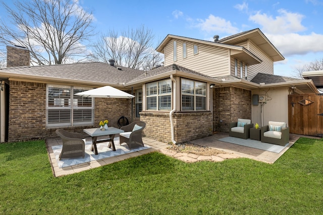 back of property featuring a yard, a patio, brick siding, and a chimney