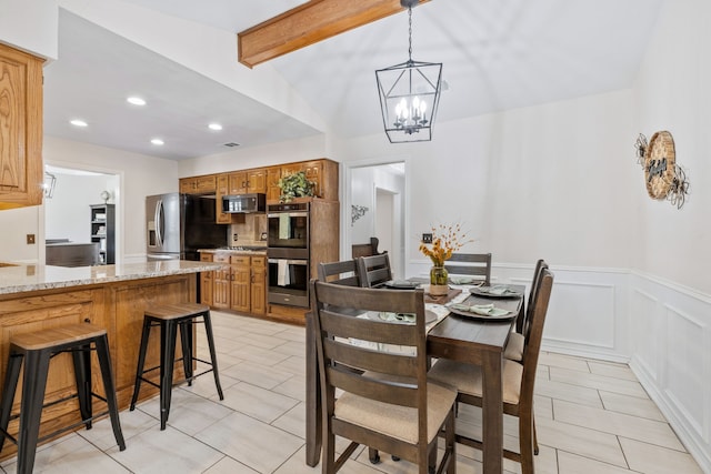 dining space featuring light tile patterned flooring, a decorative wall, wainscoting, and visible vents