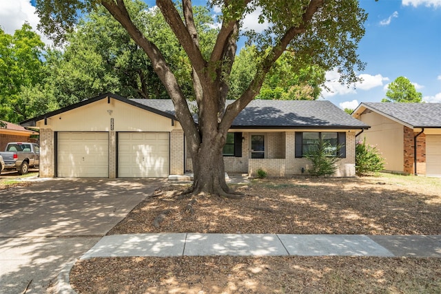 view of front facade featuring a garage, brick siding, roof with shingles, and driveway