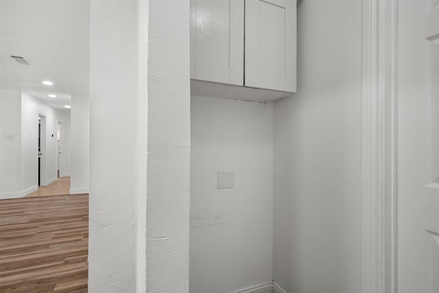 laundry room featuring visible vents, light wood-style flooring, and baseboards