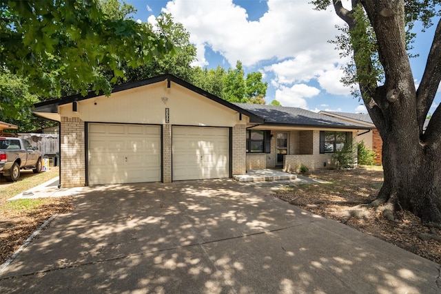 view of front of property with concrete driveway, an attached garage, and brick siding