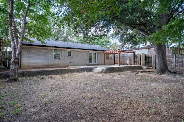 rear view of house featuring a pergola, fence, french doors, brick siding, and a patio area