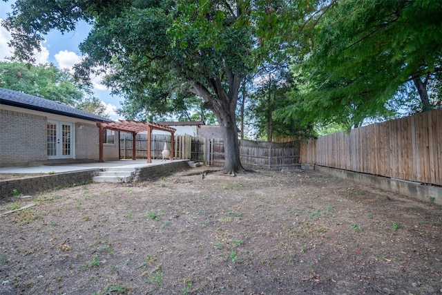 view of yard featuring a patio area, french doors, a pergola, and a fenced backyard