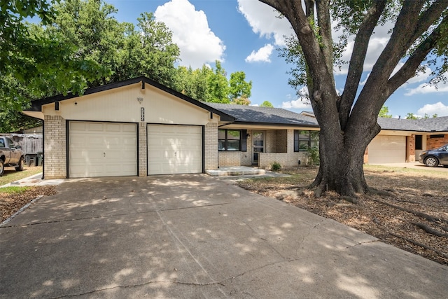 ranch-style home with a garage, brick siding, and driveway