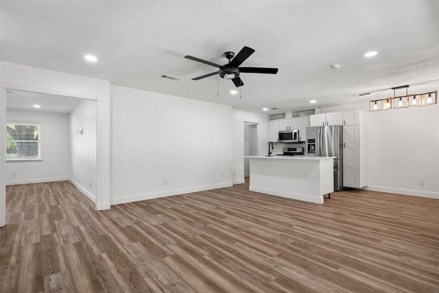 kitchen featuring wood finished floors, open floor plan, and stainless steel appliances