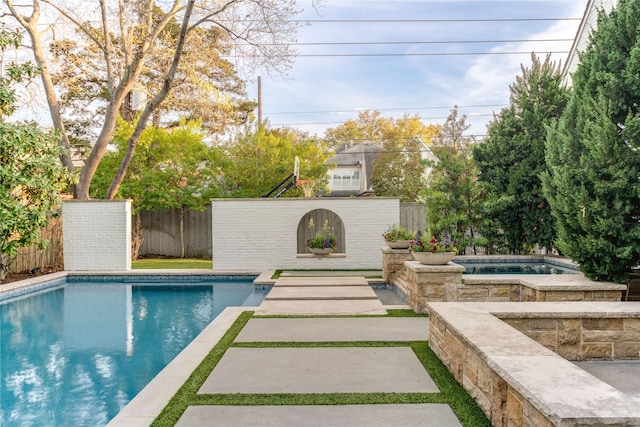 view of swimming pool featuring an in ground hot tub, a fenced in pool, and fence