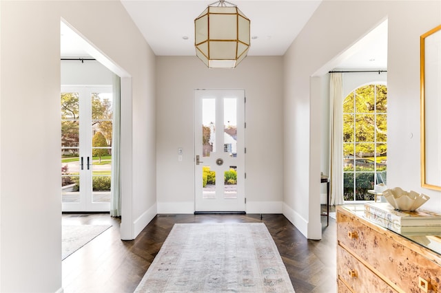 entryway featuring dark wood-style floors, french doors, and baseboards