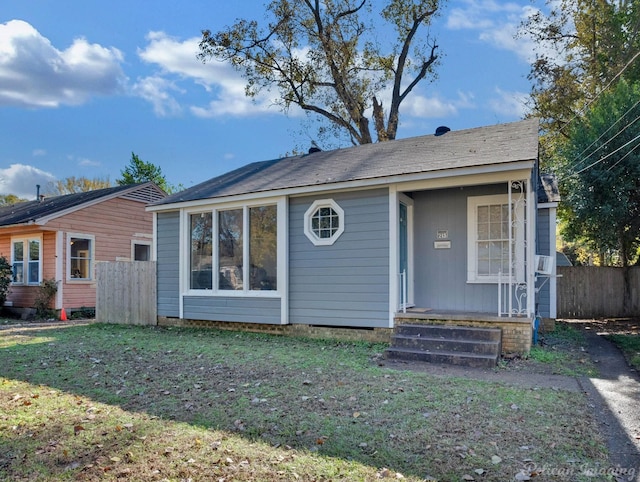 view of front facade featuring a front yard and fence