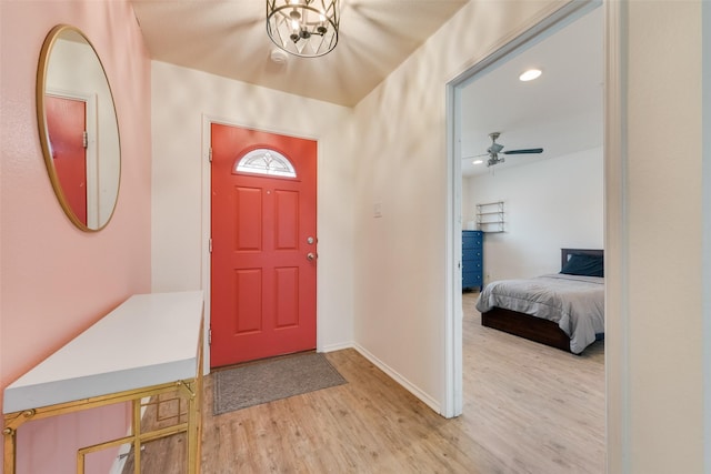 foyer entrance featuring light wood finished floors, recessed lighting, ceiling fan with notable chandelier, and baseboards