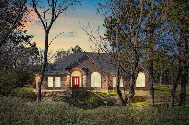 view of front of house featuring brick siding and a shingled roof