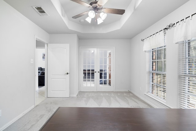 unfurnished room with visible vents, baseboards, carpet floors, french doors, and a raised ceiling