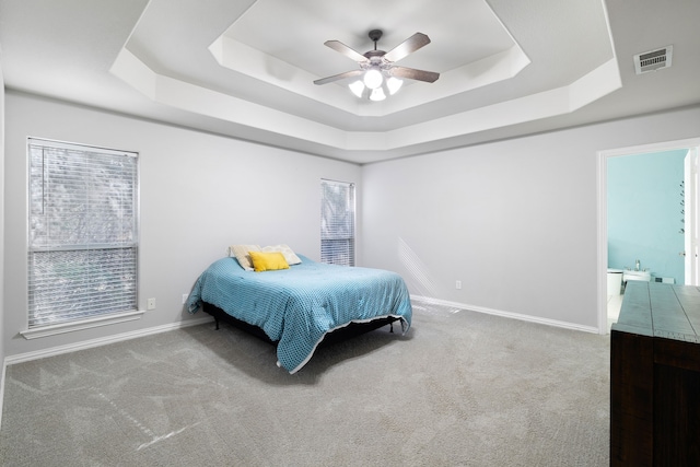 bedroom with visible vents, a raised ceiling, and carpet