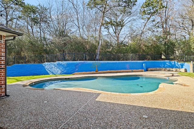 view of pool featuring a diving board, a fenced in pool, fence, and a patio