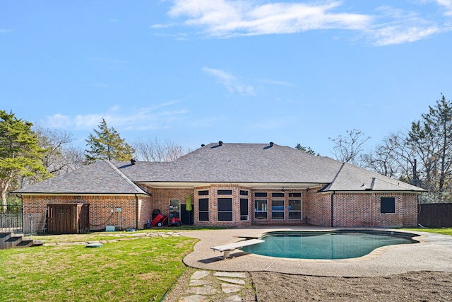 view of pool with a fenced in pool, fence, a diving board, a patio area, and a lawn