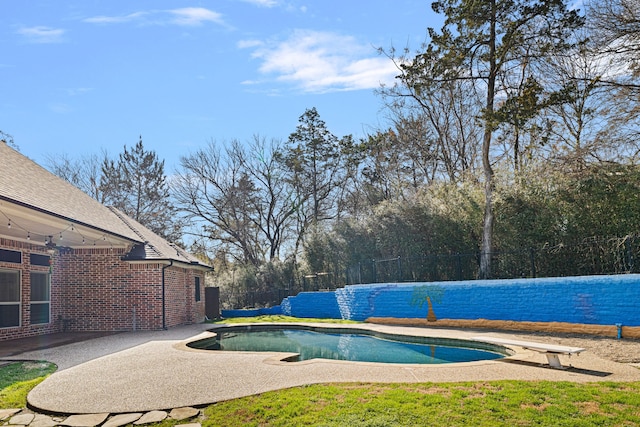 view of swimming pool with a patio area, a fenced in pool, fence, and a diving board