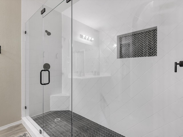 full bathroom featuring a shower stall and wood finished floors