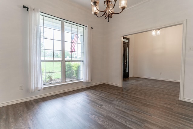 empty room with baseboards, an inviting chandelier, ornamental molding, and dark wood-style flooring