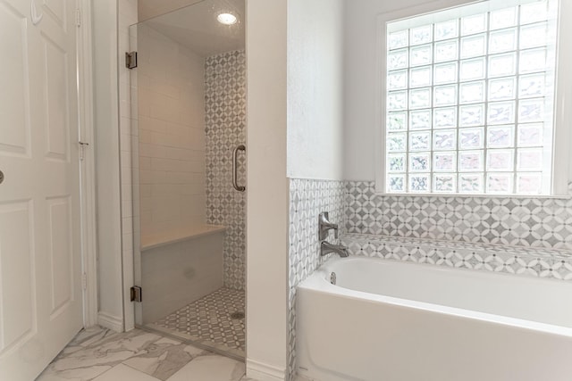 full bath featuring a wealth of natural light, a shower stall, a bath, and marble finish floor