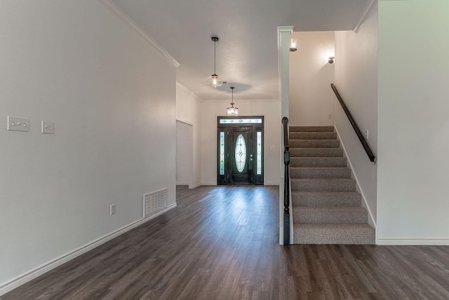 foyer entrance with stairway, baseboards, visible vents, dark wood finished floors, and ornamental molding