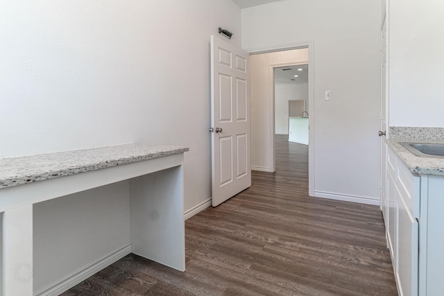 interior space with baseboards and dark wood-style flooring