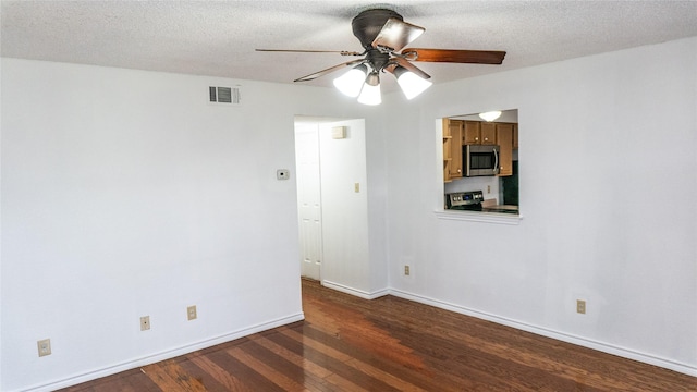 unfurnished room featuring visible vents, a textured ceiling, baseboards, and dark wood-style flooring